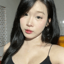 a woman with long black hair is taking a selfie .