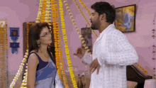 a man and a woman are standing next to each other in a room