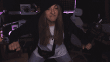 a woman in a black hat and white shirt is dancing