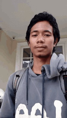 a man wearing a grey hoodie that says aol looks at the camera