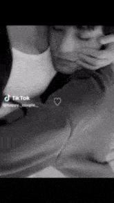a black and white photo of a man and woman with a heart on their shirt