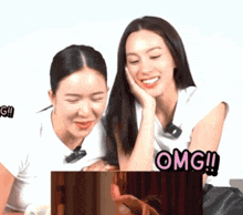 two women are sitting next to each other and one of them has the word omg on it