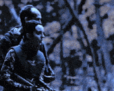 a man and a woman holding guns in a forest