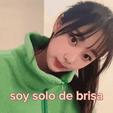 a girl wearing a green jacket with the words soy solo de brisa on the bottom