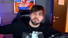 a man with a beard wearing a black shirt that says camp
