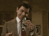 a man in a suit and tie is opening a bottle with a stapler
