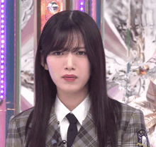 the girl is wearing a plaid suit and tie
