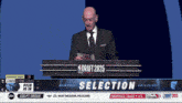 a man in a suit and tie stands at a podium that says draft 2025 on it