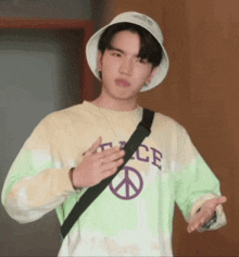 a young man wearing a hat and a shirt that says peace on it