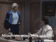 a man with glasses and a mustache is sitting at a desk with the words misschien written below him