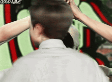 a person is holding another person 's head in front of a sign that says could nine