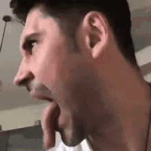 a close up of a man 's face with his mouth open and his tongue sticking out