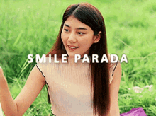 a woman is sitting in the grass and smiling with the words smile parada above her