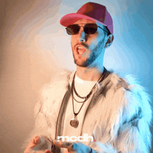 a man wearing sunglasses and a fur coat has the word modh on the bottom right