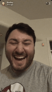 a man with a beard is laughing with bradley 21m ago written on the bottom