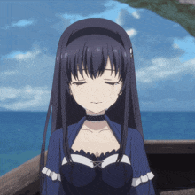 a girl with a choker on her neck is sitting in front of a body of water