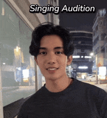 a young man standing in front of a building with the words singing audition written above him