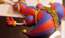 a red blue and yellow balloon with a green leaf on the tail