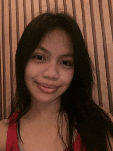 a girl with long black hair is smiling for the camera