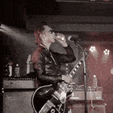a man drinking from a can while playing a guitar in front of a fender amplifier