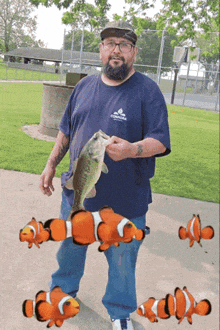 a man holding a large fish wearing a shirt that says columbia