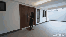 a woman is standing in a hallway in front of a door .