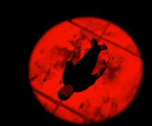 a silhouette of a person in a red circle in the dark