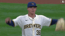 a baseball player wearing a brewers jersey throws a ball