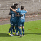 a group of soccer players are hugging each other and one of them has the number 21 on his back