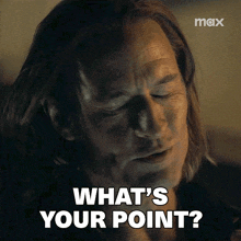 a man with long hair says " what 's your point " with his eyes closed