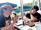 two men are sitting at a table with a napkin that says inno on it