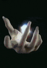 a close up of a person 's hand holding a glowing object