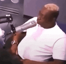a man is sitting in front of a microphone in a studio .