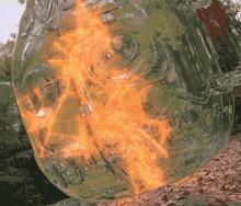 a large glass container is on fire with a flame coming out of the bottom