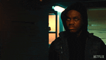 a man in a hooded jacket with a netflix logo