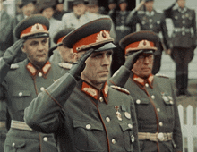 a group of men in military uniforms salute