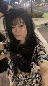 a woman with long black hair is taking a selfie with a man