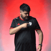 a man with a beard wearing a black adidas jersey