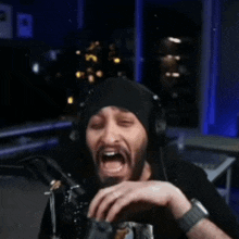 a man with a beard wearing headphones and a beanie