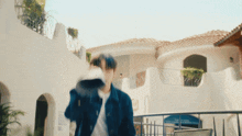 a blurry picture of a man walking in front of a white building