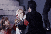 a man in a black suit has a red armband with the letter p. on it