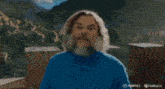 a man with a beard in a blue shirt is running in a store