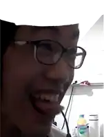 a man wearing glasses is smiling in front of a bottle of aquafina water