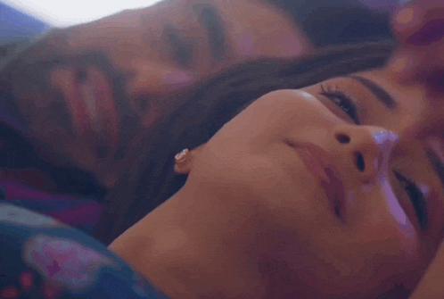 a man and a woman are kissing each other in a bed .