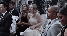 a group of people sitting in chairs at a wedding ceremony