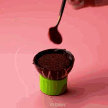a person is decorating a cupcake with frosting and the word mr.cakes is on the bottom right