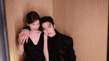 a man and a woman are sitting next to each other on a wall .