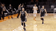 a uconn basketball player wearing number 5 runs towards the court