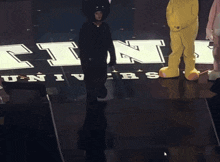 a person in a black cat costume is standing in front of a sign that says universal