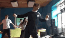 a group of young people are dancing in a room while holding hands .